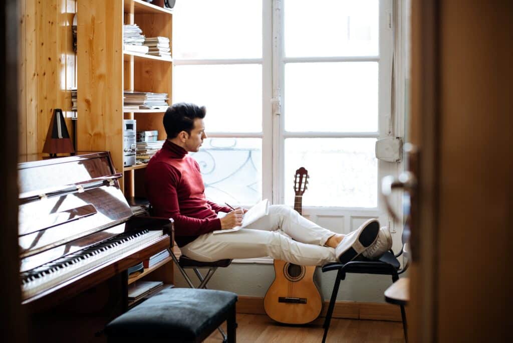Songwriter with notebook by a window